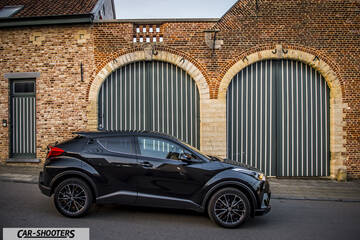 Toyota C HR – side profile, black against a brick building