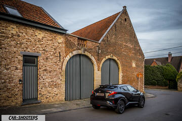 Toyota C HR – rear three-quarter, black parked near a brick building