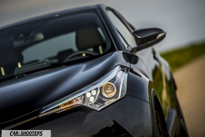 Toyota C HR – front three-quarter, black on a country road