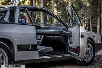 Lancia Beta Montecarlo – side profile, silver in a wooded area with open door