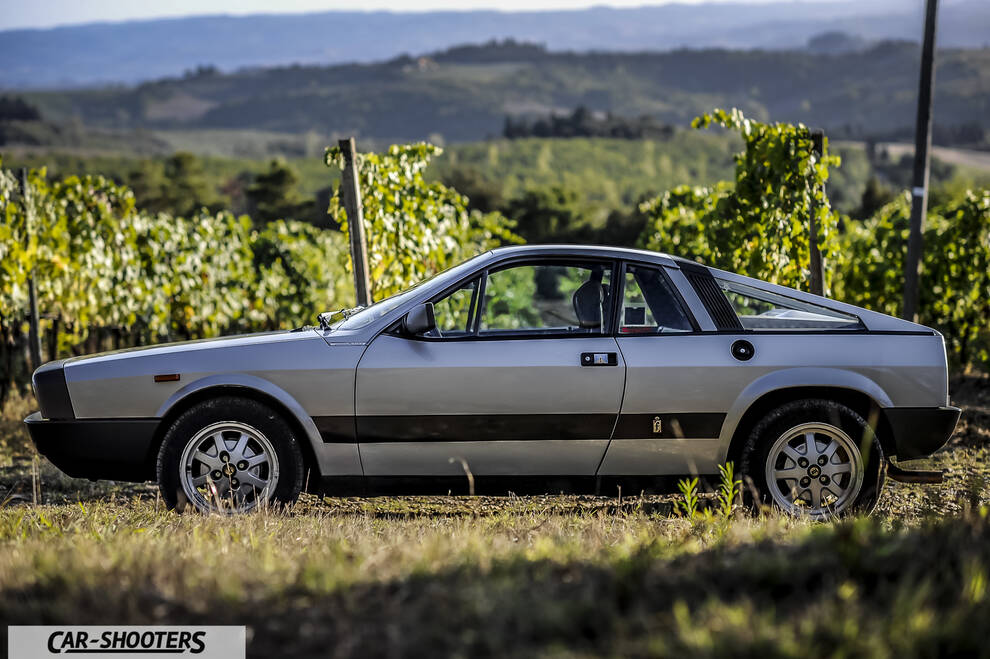 Lancia Beta Montecarlo – side profile, silver against a vineyard backdrop
