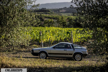 Lancia Beta Montecarlo – side profile, silver against a vineyard backdrop