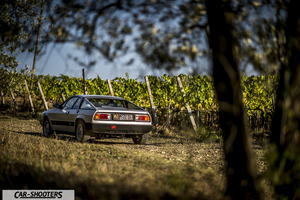 Lancia Beta Montecarlo – rear three-quarter, silver on a dirt path by vineyard
