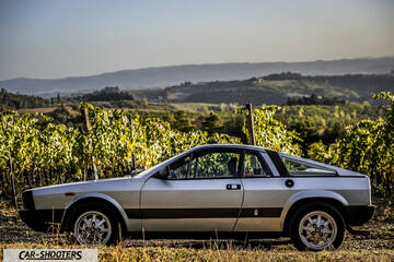 Lancia Beta Montecarlo – side profile, silver against a hilly landscape