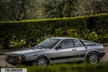 Lancia Beta Montecarlo – side profile, silver parked near a green hedge