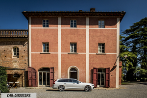 Volvo V90 T8 – side profile, white in front of a building