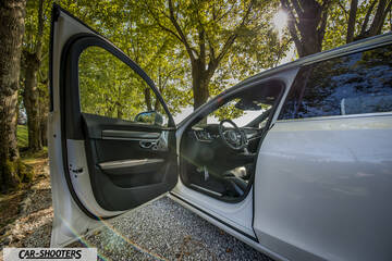 Volvo V90 T8 – side profile, white with door open under trees