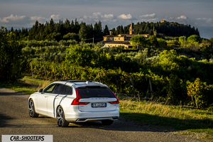 Volvo V90 T8 – rear three-quarter, white against a mountain backdrop