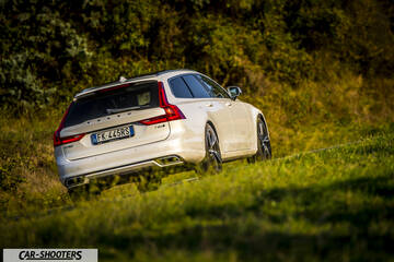 Volvo V90 T8 – rear three-quarter, white on a grassy hill