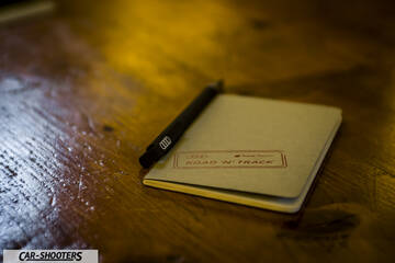 Audi – detail, notebook and pen on wooden table