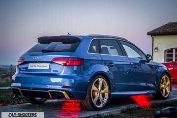 Audi – rear three-quarter, blue parked near a building