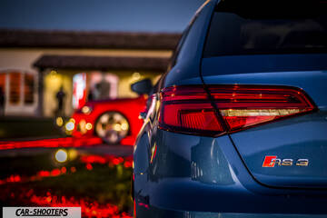 Audi – rear three-quarter, blue parked near a building