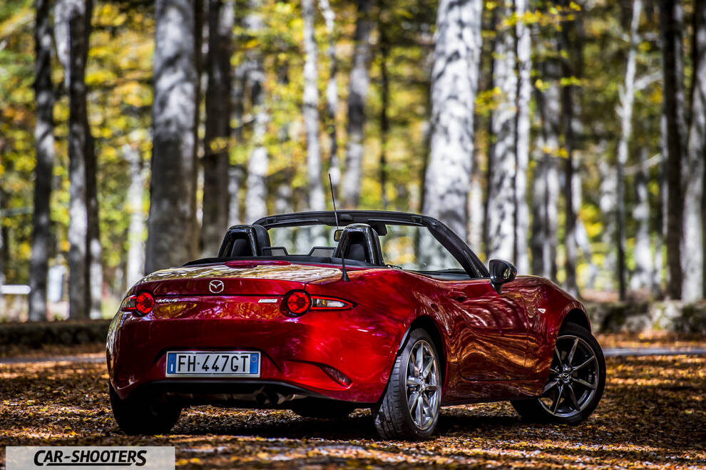 Mazda MX 5 ND – rear three-quarter, red metallic on a forest road