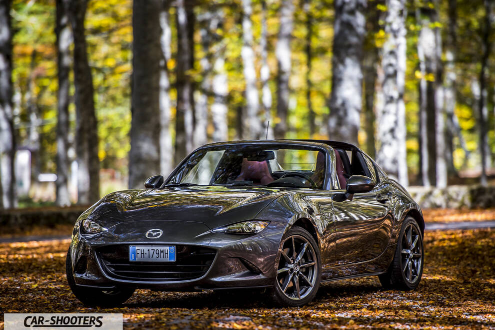 Mazda MX 5 ND – front three-quarter, grey metallic on a road in the woods