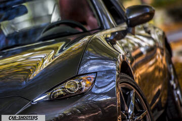 Mazda MX 5 ND – front three-quarter, grey metallic outdoors with autumn foliage reflections