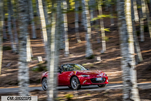 Mazda MX 5 ND – front three-quarter, red driving on a forested road