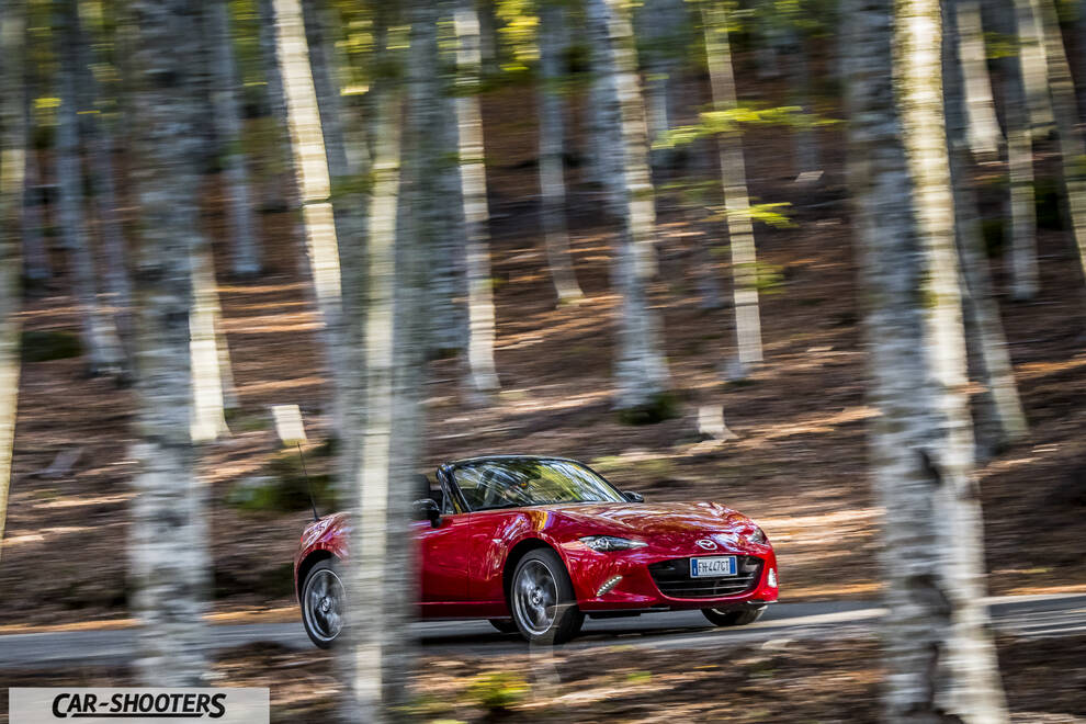 Mazda MX 5 ND – front three-quarter, red driving on a forested road