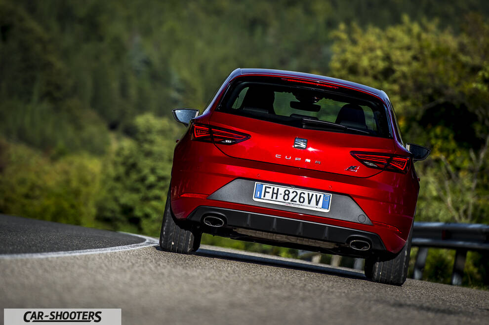 Seat Leon Cupra – rear view, red metallic on a winding country road