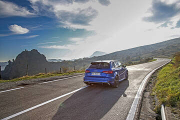 rear three-quarter, blue on a winding country road