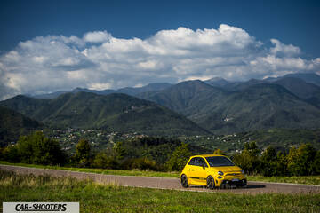 Abarth 595 Competizione – front three-quarter, yellow against a mountain backdrop