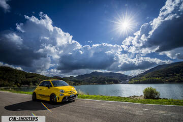 Abarth 595 Competizione – front three-quarter, yellow against a mountain backdrop