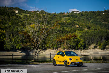 Abarth 595 Competizione – front three-quarter, yellow against a mountain backdrop
