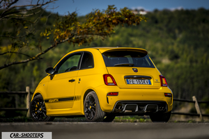 Abarth 595 Competizione – rear three-quarter, yellow against a wooded hillside
