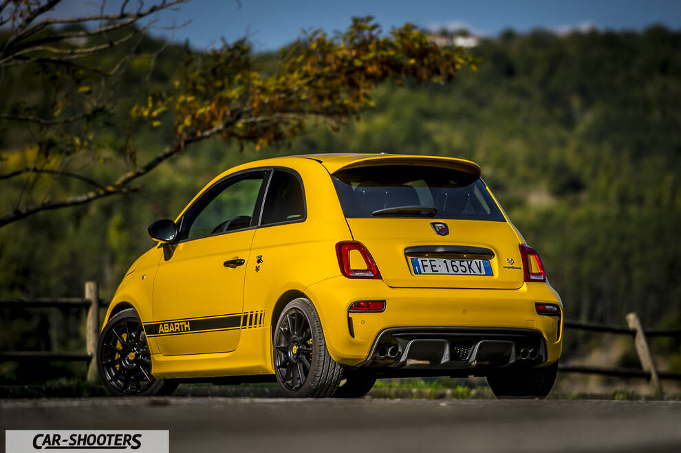 Abarth 595 Competizione – rear three-quarter, yellow against a wooded hillside