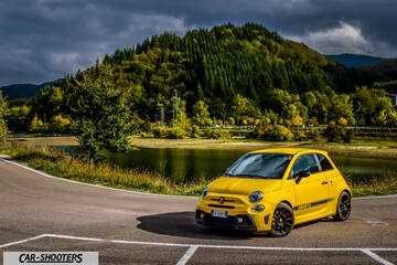 Abarth 595 Competizione – front three-quarter, yellow against a mountain backdrop