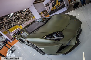 front three-quarter, matte green at a car show