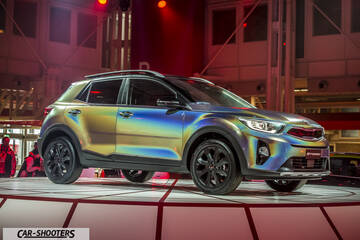 front three-quarter, iridescent wrap on an auto show stage