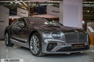 front three-quarter, grey metallic on an auto show floor