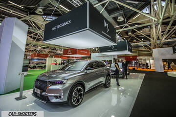 front three-quarter, silver metallic on an auto show floor