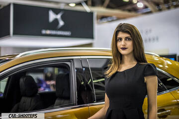 side profile, gold metallic at an auto show