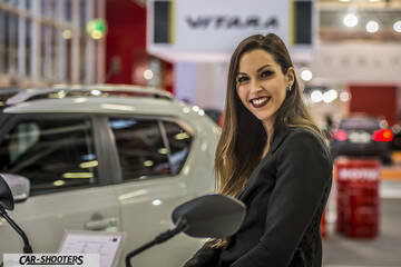 side profile, white at an auto show