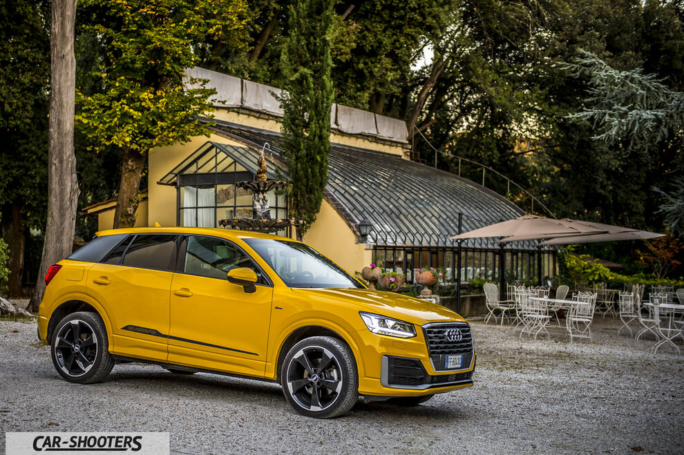 Audi Q2 – front three-quarter, yellow parked near an old building