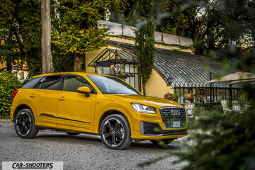Audi Q2 – front three-quarter, yellow against a historic building backdrop