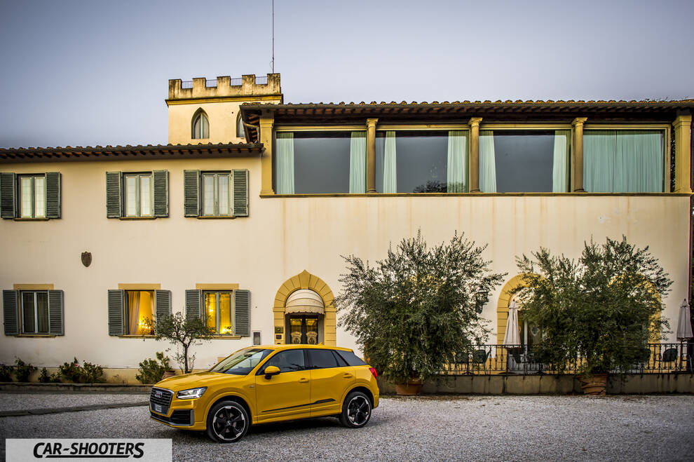 Audi Q2 – front three-quarter, yellow in front of a large building