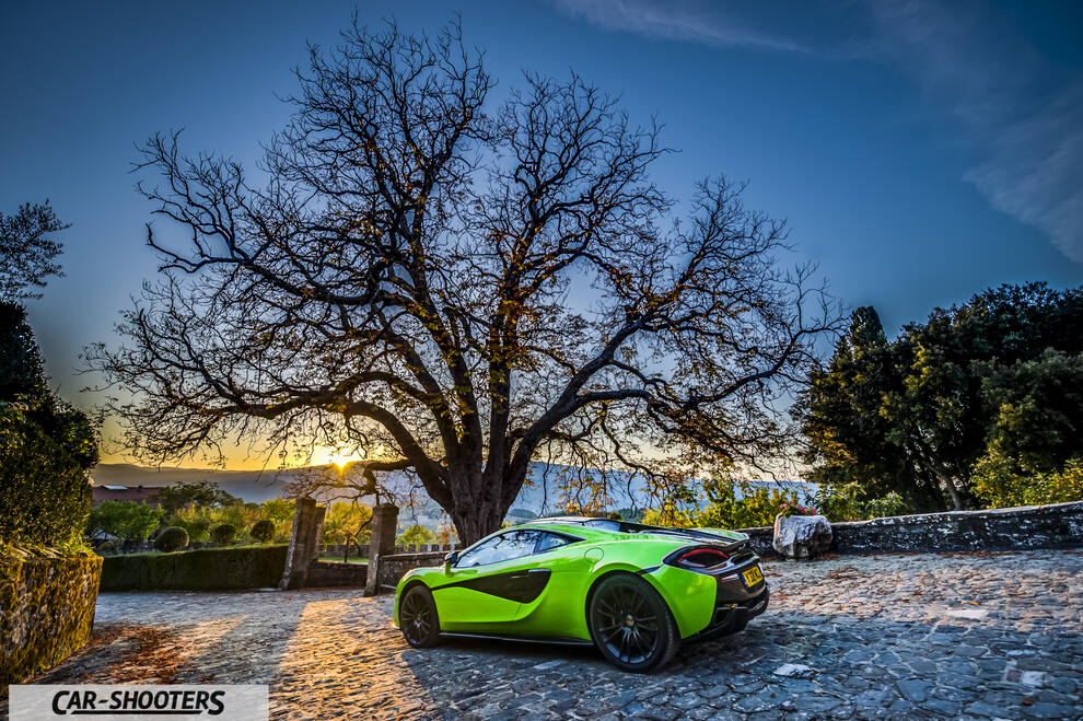 Mclaren 570S – rear three-quarter, bright green parked on a cobblestone courtyard