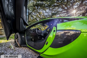 Mclaren 570S – side profile, green with open scissor doors parked outdoors