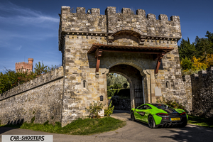 Mclaren 570S – rear three-quarter, bright green in front of a stone castle gate
