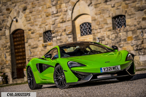Mclaren 570S – front three-quarter, bright green against a stone building