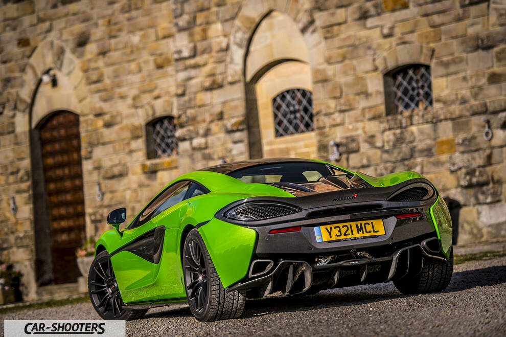 Mclaren 570S – rear three-quarter, bright green against a stone building