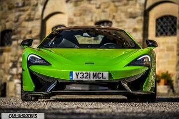 Mclaren 570S – front three-quarter, bright green against a stone building