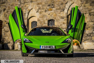 Mclaren 570S – front three-quarter, bright green against a stone building