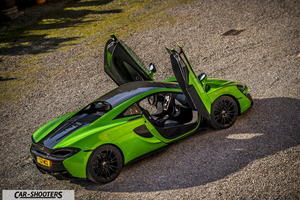 Mclaren 570S – rear three-quarter, green metallic with doors open on gravel