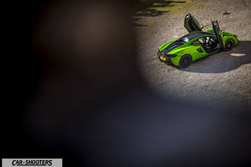 Mclaren 570S – rear three-quarter, green with doors open on gravel