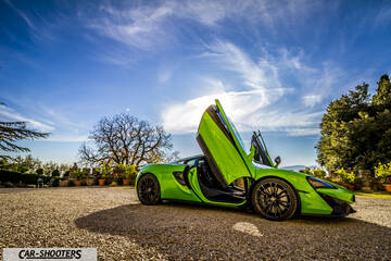 Mclaren 570S – side profile, green on a gravel courtyard