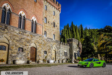 Mclaren 570S – front three-quarter, bright green parked in front of a castle