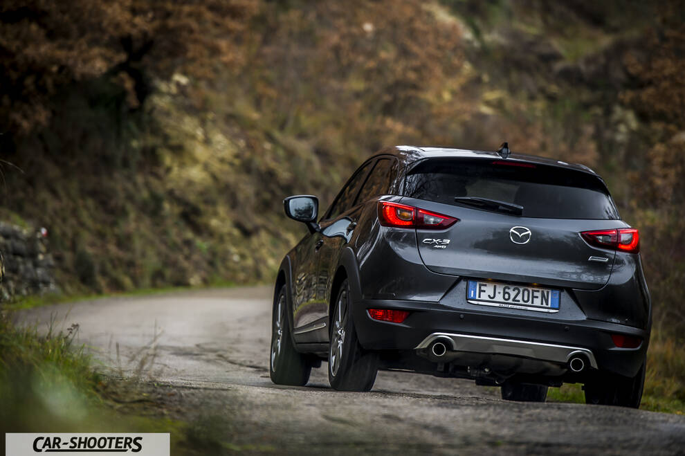 Mazda CX 3 – rear three-quarter, dark grey metallic on a country road